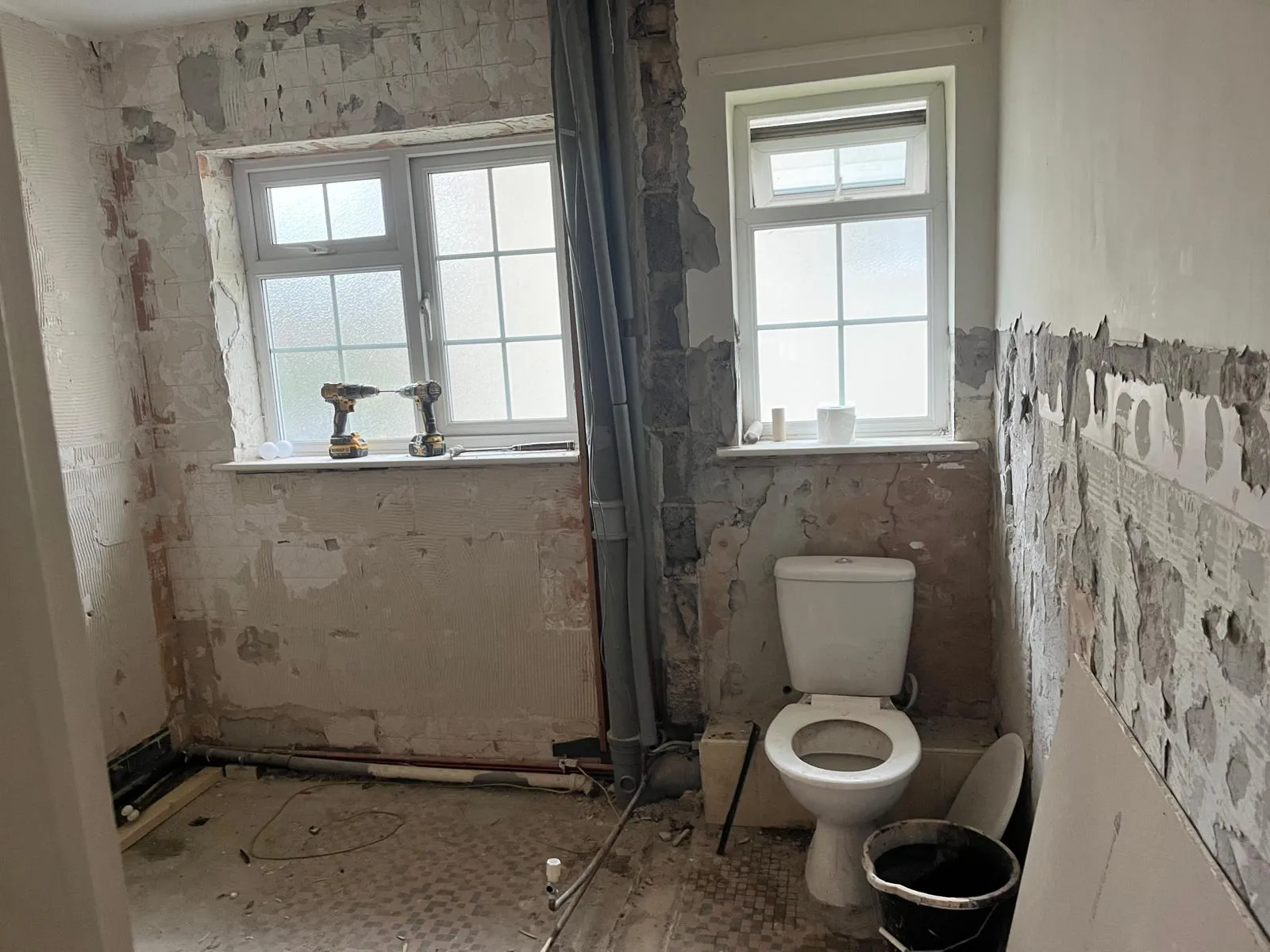 Original bathroom with the old tiles removed and the toilet still in place