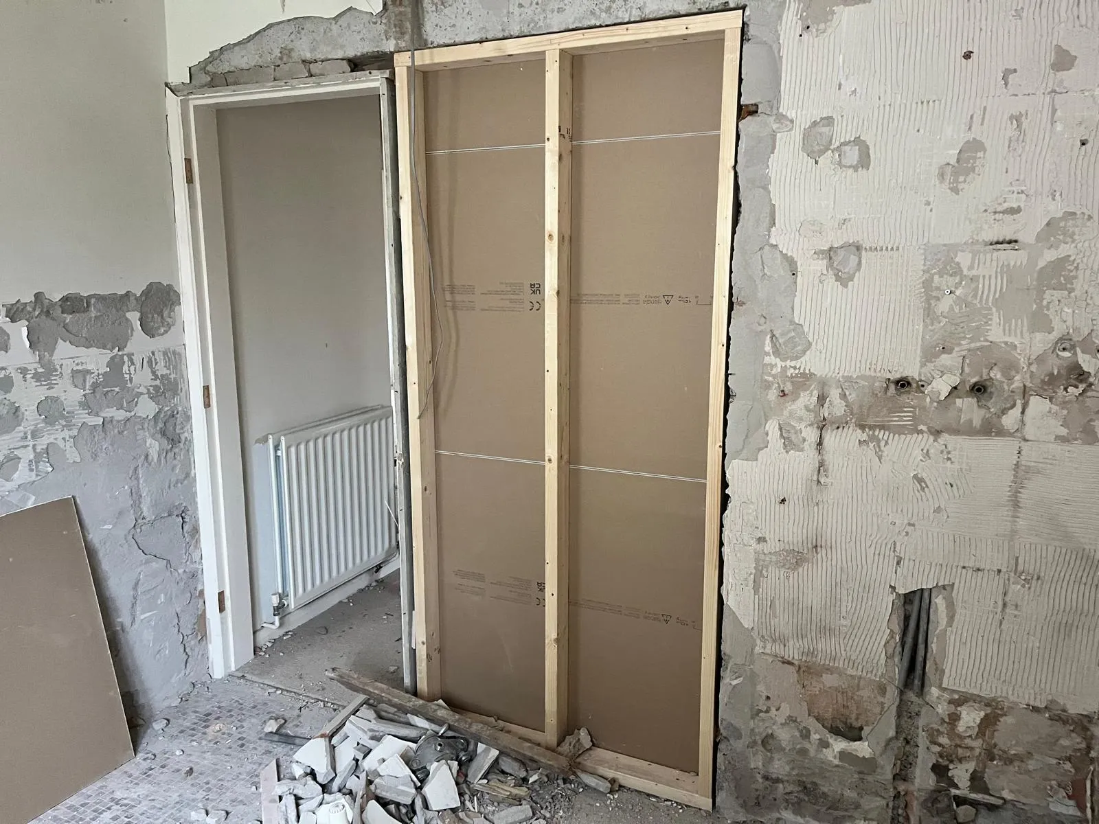 New timber stud wall being boarded during the bathroom strip-out