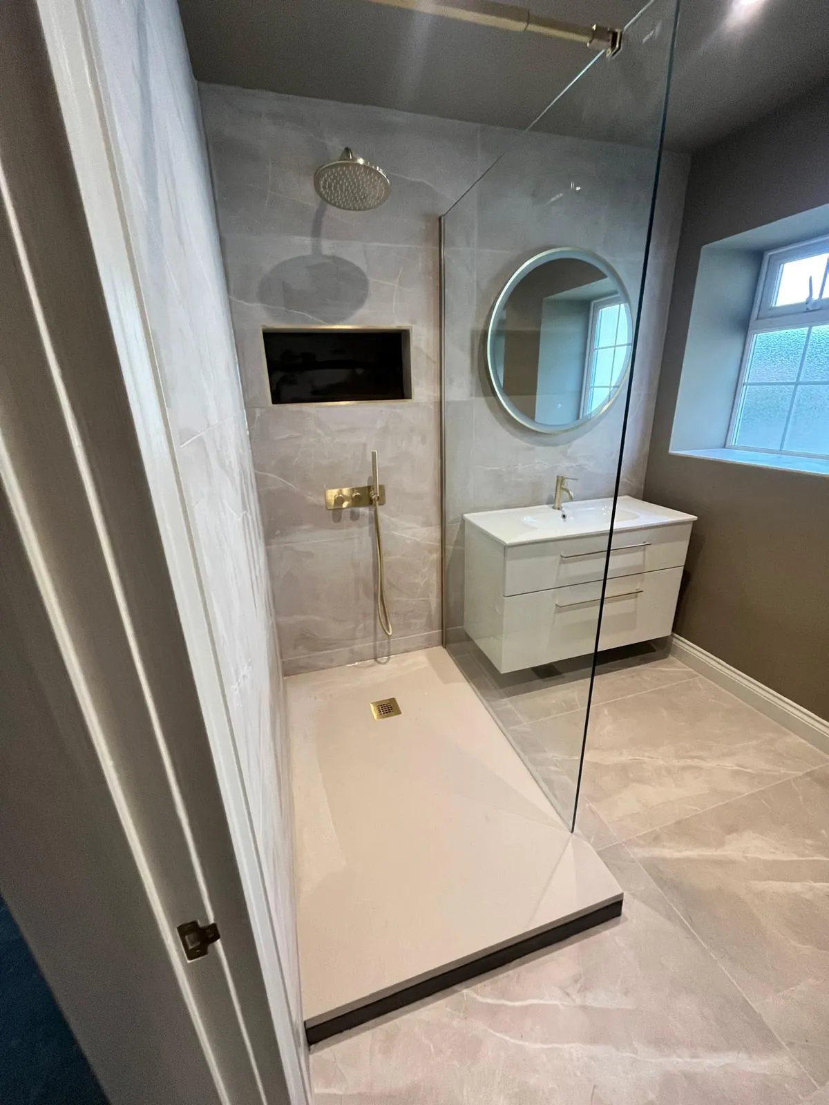 Walk-in shower with a rainfall shower head and glass screen