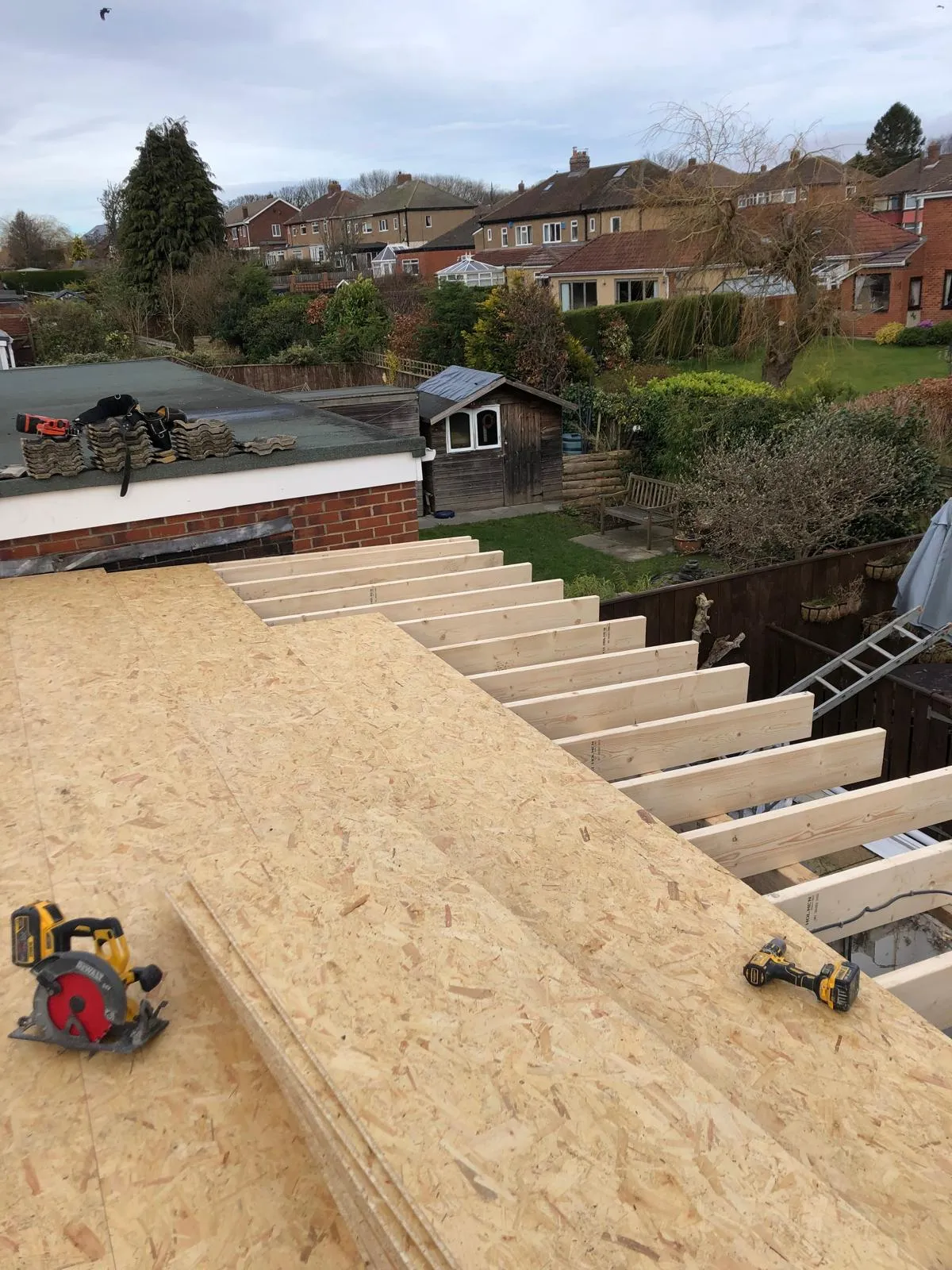 New roof joists and decking boards being fitted to the extension