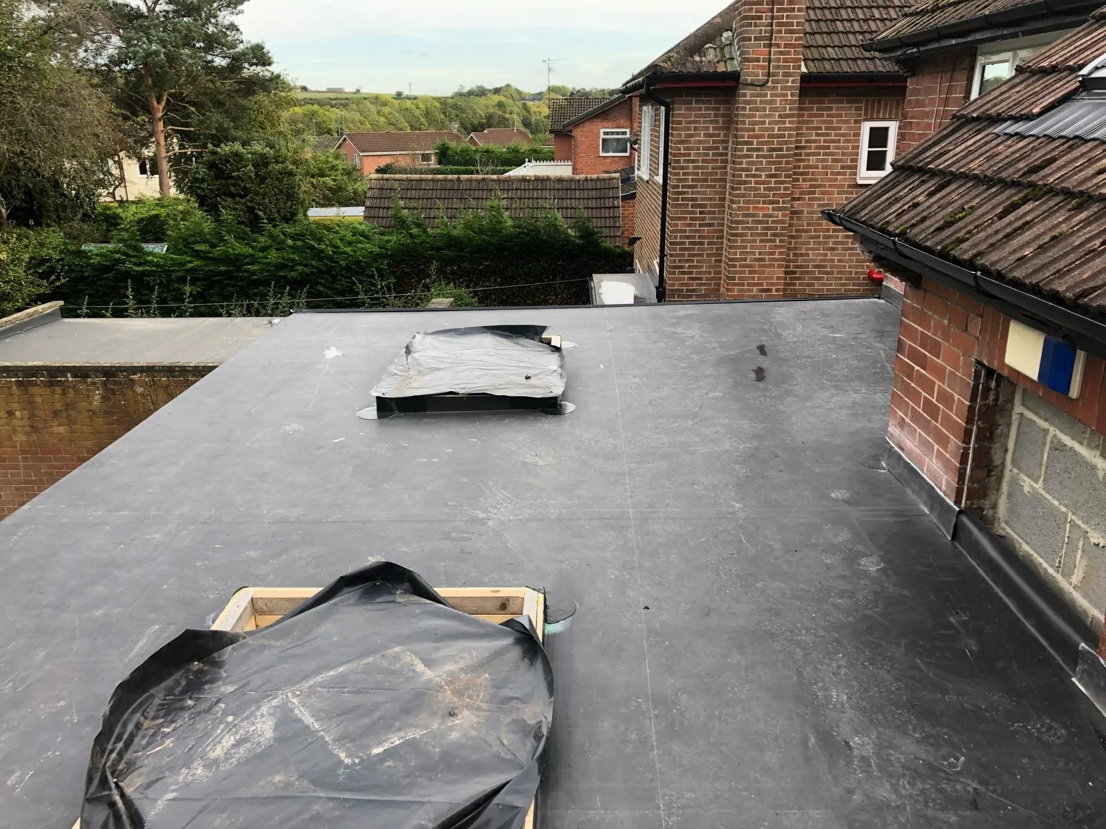 Newly covered flat roof with its two rooflight openings protected