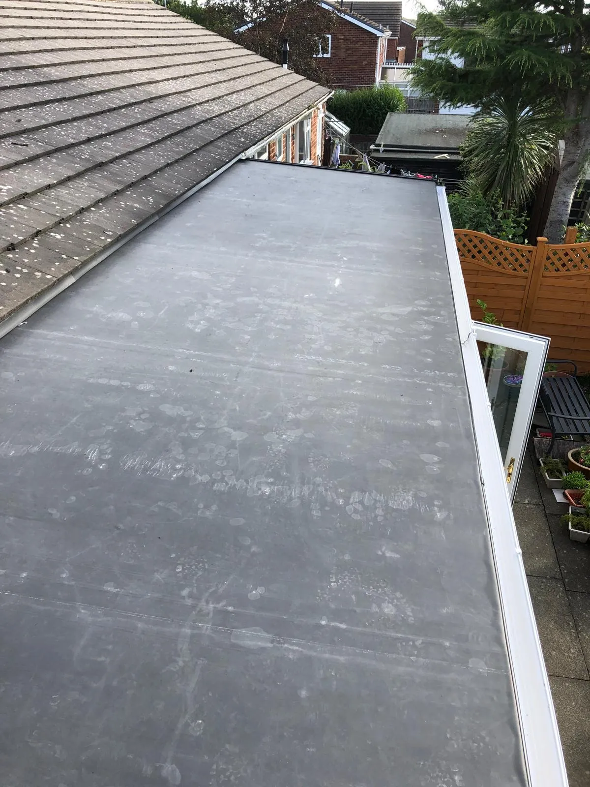Completed flat roof running alongside a tiled pitched roof