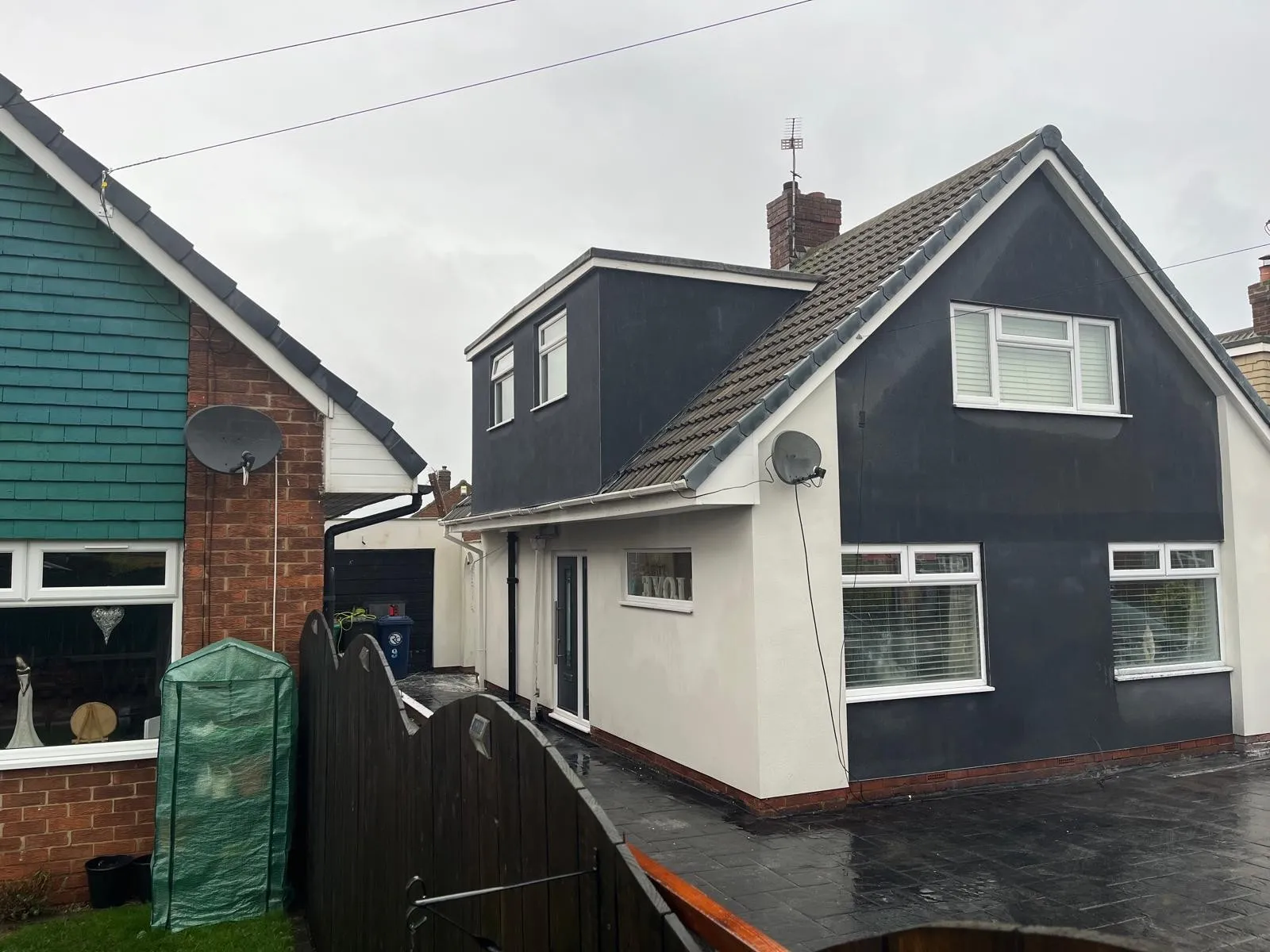 Rendered house seen from the garden, with white walls and a dark grey gable