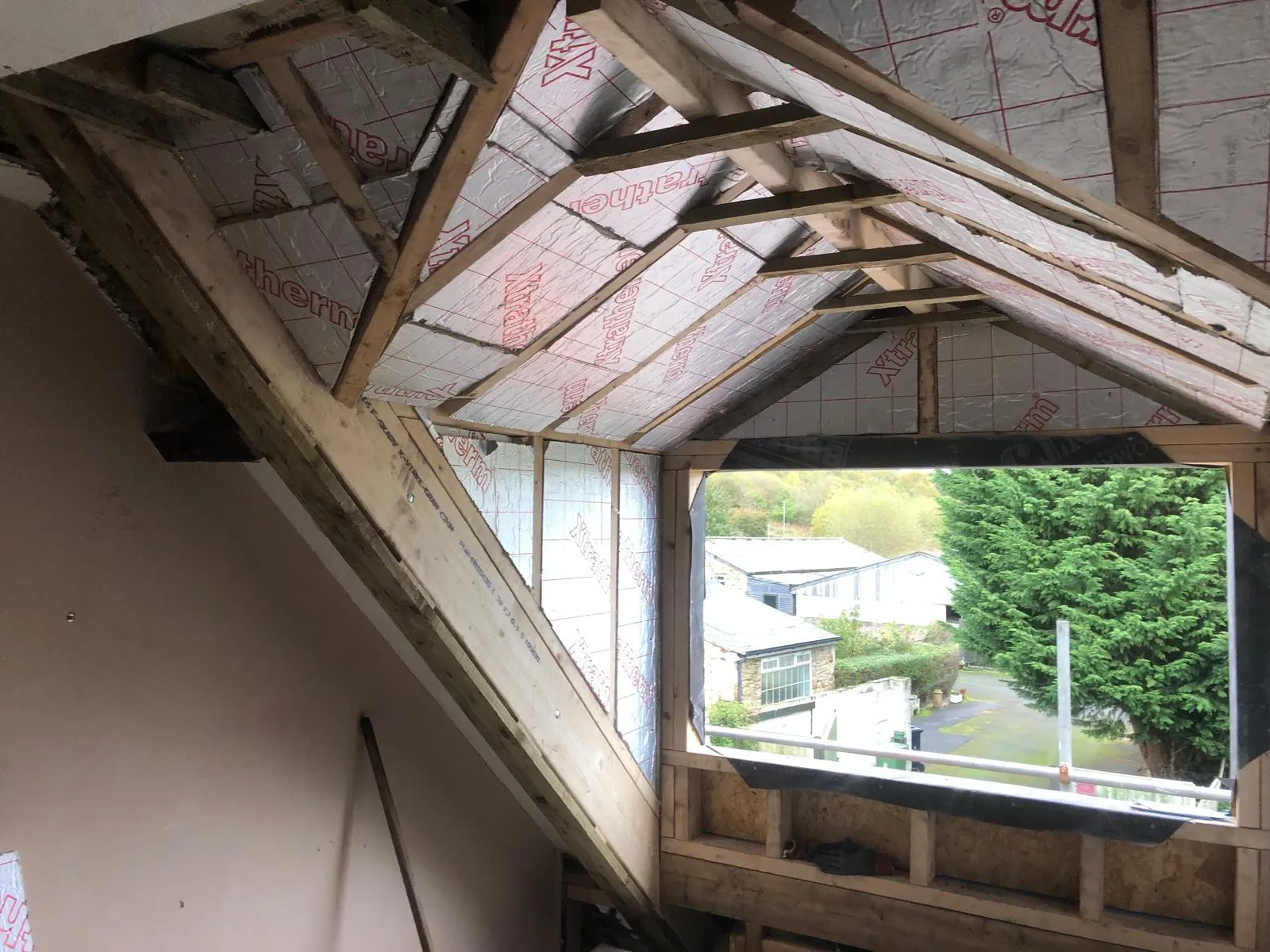 Inside a new dormer, with timber framing, insulation boards and the window opening