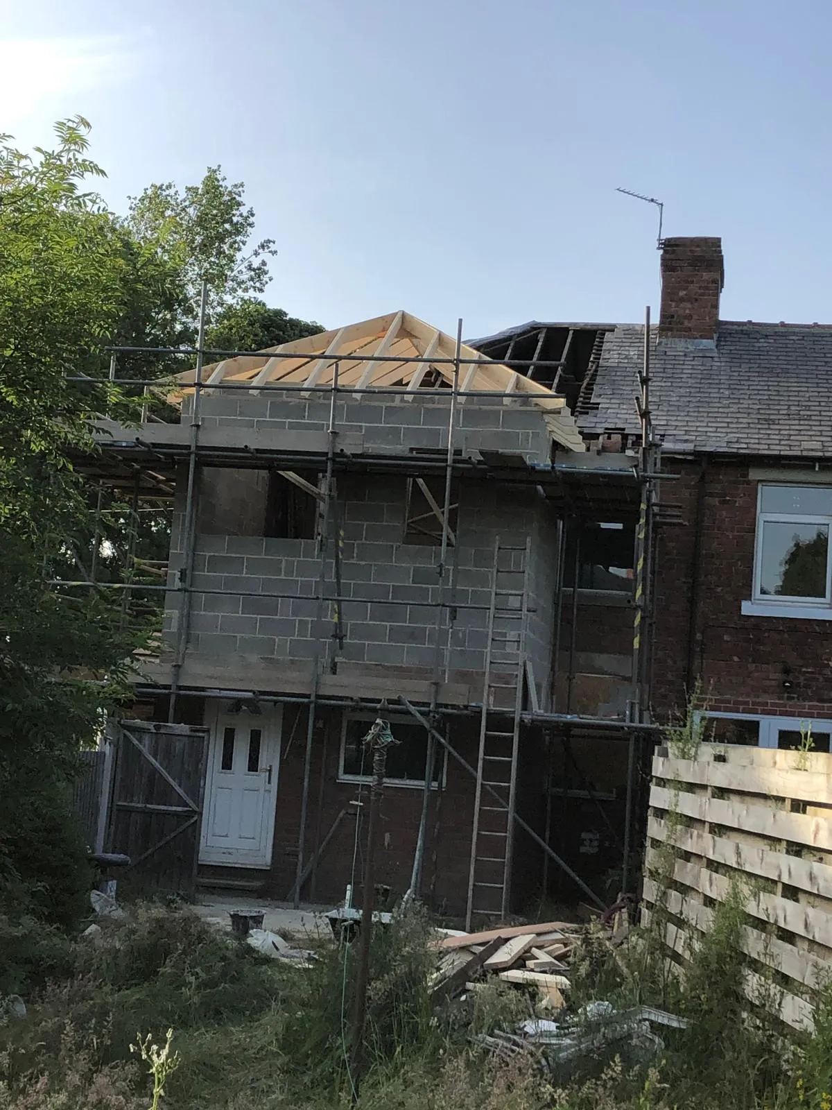 Back of the house with the blockwork extension and its new roof timbers under scaffold